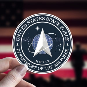 May include: A round sticker with a blue background and white text. The text reads "United States Space Force Department of the Air Force". A white star and a silver arrow with a blue globe are in the center of the sticker. The year "MMXIX" is printed below the arrow.