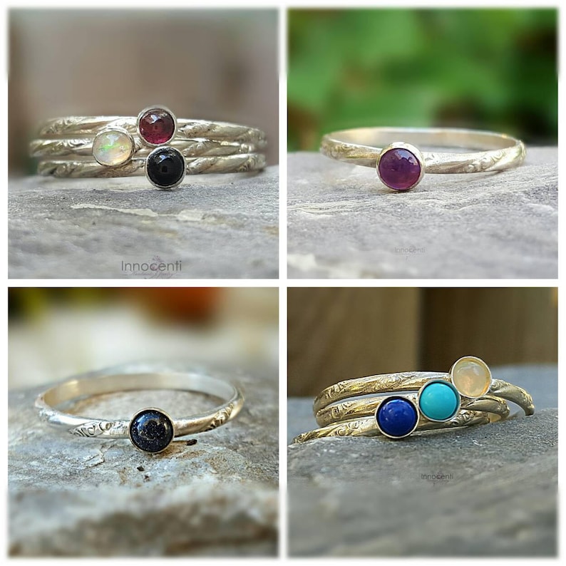 Puede incluir: Anillos de plata con diferentes piedras preciosas. Los anillos presentan piedras redondas en colores como &oacute;palo, rub&iacute;, negro, azul y turquesa. Los anillos tienen un dise&ntilde;o de banda texturizada. La marca "Innocenti" es visible.