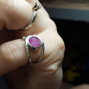 K&ouml;nnte beinhalten: Zwei Silberringe mit Edelsteinen. Der Ring links hat einen kleinen, klaren Edelstein. Der Ring rechts hat einen gr&ouml;&szlig;eren, rosafarbenen Edelstein.