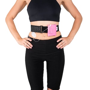 A model, whose belly button and lower rib cage are exposed, is wearing a Pumpcases™ hot pink, adjustable, insulin pump waist belt, compatible with t:slim X2 made for Diabetics. This belt is placed above her belly button.