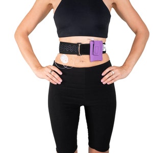 A model, whose belly button and lower rib cage are exposed, is wearing a Pumpcases™ lavender purple, adjustable, insulin pump waist belt, compatible with t:slim X2 made for Diabetics. This belt is placed above her belly button.