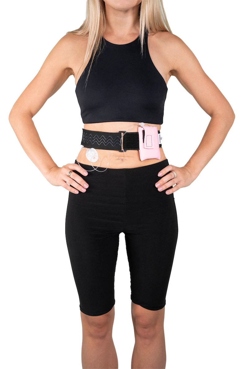 A model, whose belly button and lower rib cage are exposed, is wearing a Pumpcases™ rose pink, adjustable, insulin pump waist belt, compatible with t:slim X2 made for Diabetics. This belt is placed above her belly button.