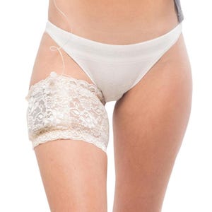 Side view of white bridal lace garter on upper thigh, smooth discreet fit under lingerie, wedding pump garter