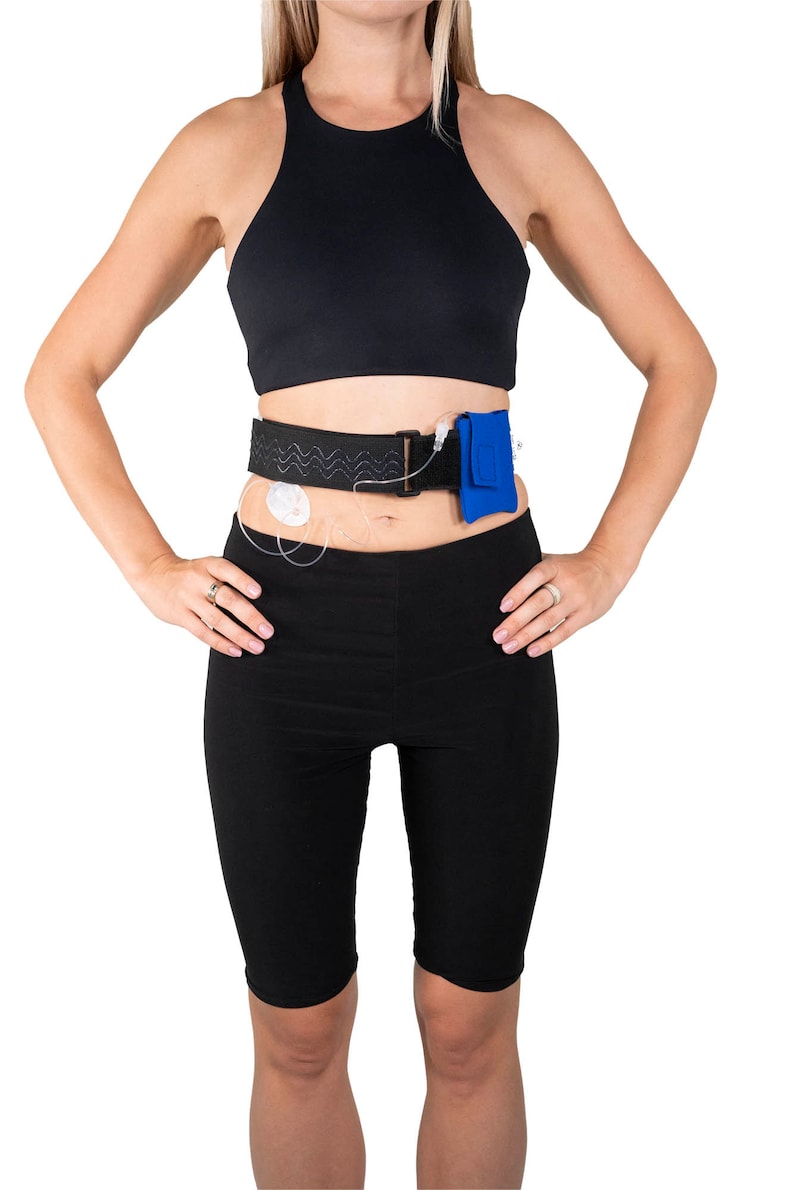 A model, whose belly button and lower rib cage are exposed, is wearing a Pumpcases™ royal blue, adjustable, insulin pump waist belt, compatible with t:slim X2 made for Diabetics. This belt is placed above her belly button.