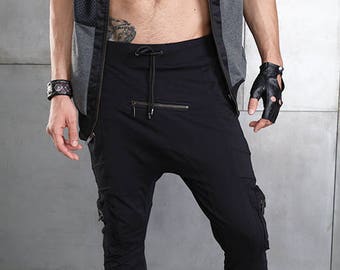 May include: Black cargo pants with a zipper detail and a drawstring waist. The pants have a relaxed fit and are made of a soft, comfortable fabric.