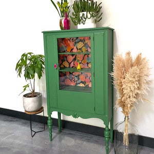 Antique cabinet painted green with floral face wallpaper geode handle