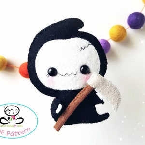 May include: A black and white felt plush toy of the Grim Reaper with a brown scythe. The toy has a cute, cartoonish face with big eyes and a stitched-on smile. The toy is holding the scythe in its right hand.