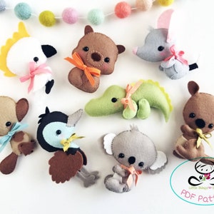 May include: A set of eight felt animal plushies, including a koala, kangaroo, echidna, wombat, crocodile, kookaburra, and two other animals. The plushies are all brown, gray, green, or blue and have black eyes and pink noses. The plushies are arranged on a white background. The text "Little Things to Share PDF Pattern" is visible in the bottom right corner of the image.