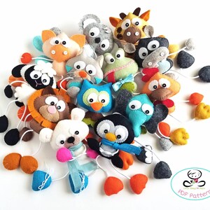 May include: A set of felt animal toys with hanging loops. The animals include a giraffe, owl, penguin, frog, lion, chicken, bear, and more. The toys are colorful and have a variety of textures. The set includes a PDF pattern for making the toys.