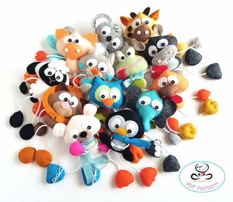 May include: A set of felt animal toys with hanging loops. The animals include a giraffe, owl, penguin, frog, lion, chicken, bear, and more. The toys are colorful and have a variety of textures. The set includes a PDF pattern for making the toys.