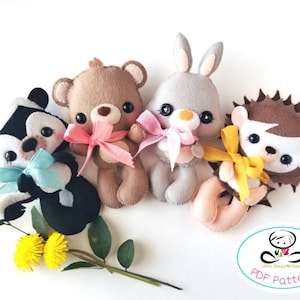 May include: Four felt animal plushies: a brown bear, a grey bunny, a black and white skunk, and a brown hedgehog. Each plush is holding a ribbon bow in a different colour. The plushies are arranged in a semi-circle on a white background. The text "PDF Pattern" is visible in the lower right corner of the image.