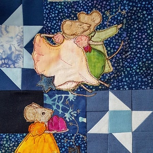 Könnte beinhalten: Eine blaue und weiße Patchwork-Decke mit aufgenähten tanzenden Mäusen. Die Mäuse tragen bunte Kleider und Anzüge. Die Decke ist mit Sternen und Schneeflocken verziert.