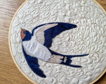 Finished Textile Art mounted I0" hoop flying swallow on cream cotton