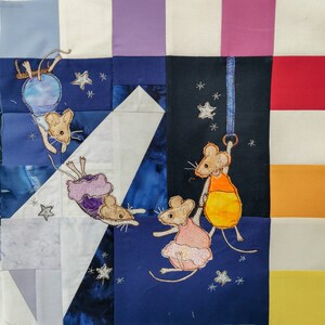 Könnte beinhalten: Eine blaue und weiße Patchwork-Decke mit einem verspielten Design mit vier Mäusen. Die Mäuse sind detailliert gestickt und halten an einem Seil, einem Ballon und einem Stern fest. Die Decke ist perfekt für ein Kinderzimmer oder ein Babyzimmer.