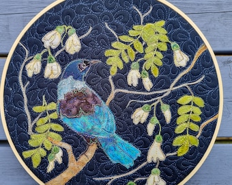 Finished Textile Art mounted I0" hoop with Tui bird and Kowhai tree on linen navy and quilted texture