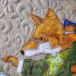 May include: A close-up of a fox wearing glasses and a green jacket. The fox is holding a stick with a red and orange object on the end. The fox is surrounded by other fabric animals, including a bird with a blue bow tie.