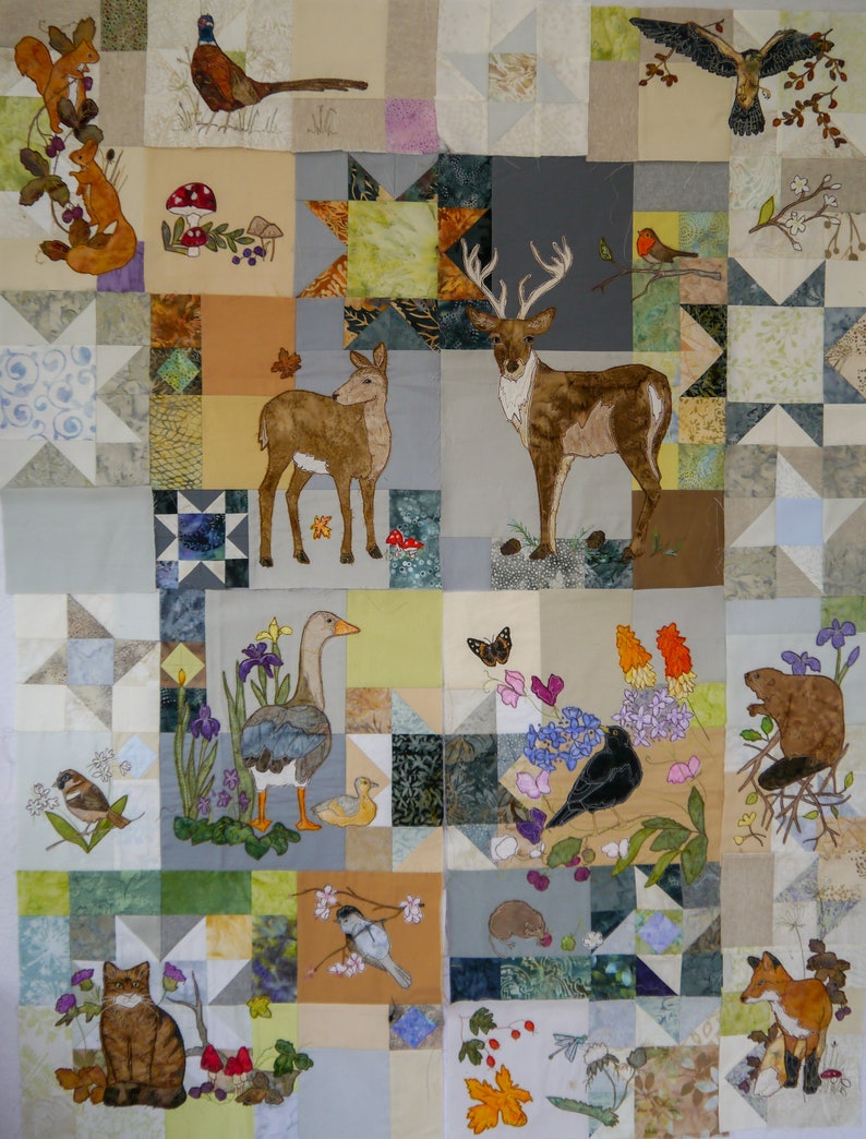 May include: A colourful patchwork quilt featuring various animal and nature scenes. The quilt depicts a deer, a goose, a pheasant, a squirrel, a fox, a bird, a butterfly, and a beaver. The quilt is made from different fabrics and colours, including brown, green, blue, and yellow.