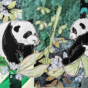 Peut inclure: Deux pandas noirs et blancs sont brodés sur un fond de tissu vert et blanc. Les pandas sont entourés de feuilles et de fleurs vertes.