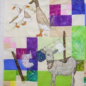 Peut inclure: Une courtepointe en patchwork avec un fond vert, violet et bleu. La courtepointe présente une chèvre blanche avec un collier brun, trois oies blanches et un canard brun. La courtepointe est décorée de divers tissus, notamment des imprimés floraux et des motifs géométriques.
