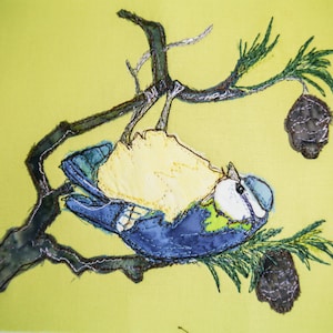 Könnte beinhalten: Ein blauer Vogel mit gelber Brust, der auf einem Zweig mit Kiefernnadeln und Zapfen sitzt. Der Vogel ist auf einem gelben Stoffhintergrund gestickt.