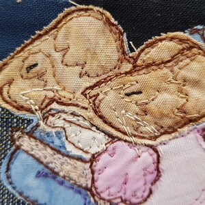 Könnte beinhalten: Zwei braune Stoffmäuse sind zusammengenäht, eine trägt ein blaues und weißes Kleid und die andere ein rosa Kleid. Die Mäuse umarmen sich.