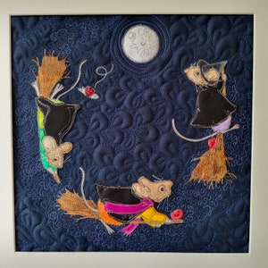 May include: A blue quilted fabric with a whimsical design featuring three mice wearing hats and holding brooms. The mice are flying through the air with a full moon in the background.