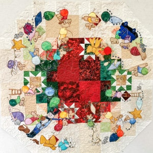 May include: A quilted Christmas tree wall hanging with a red and green patchwork center. The tree is decorated with mice, ornaments, and lights. The background is a cream color.