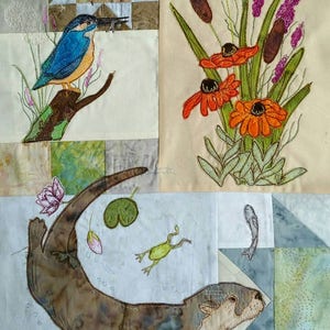 Könnte beinhalten: Eine Patchwork-Decke mit gestickten Bildern eines Eisvogels, der auf einem Ast sitzt, eines Frosches, eines Seerosenblattes, eines Otters, der schwimmt, und eines Straußes orangefarbener Blumen mit Rohrkolben.