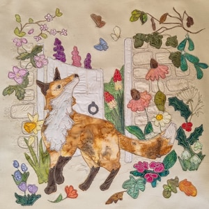 Może przedstawiać: Fantazyjna haftowana ozdoba ścienna przedstawiająca lisa z białym kołnierzem, otoczonego kolorowymi kwiatami i liśćmi. Lis stoi przed białymi drzwiami z metalowym pierścieniem.