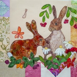 May include: A brown and white rabbit with long ears sits in a field of green leaves and white flowers. A second brown rabbit with long ears sits behind the first rabbit, with green leaves and red berries above its head.