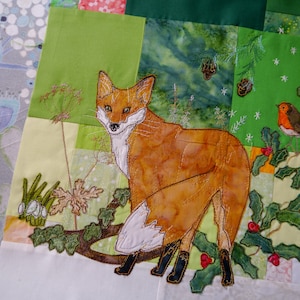 May include: A brown fox with white markings stands in a green and white embroidered scene. The fox is surrounded by green leaves and red berries. A small red robin bird is perched on a branch in the top right corner of the image.