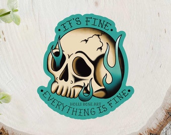 Puede incluir: Una pegatina azul turquesa con una calavera blanca y llamas. El texto en la pegatina dice "Está bien. Todo está bien."