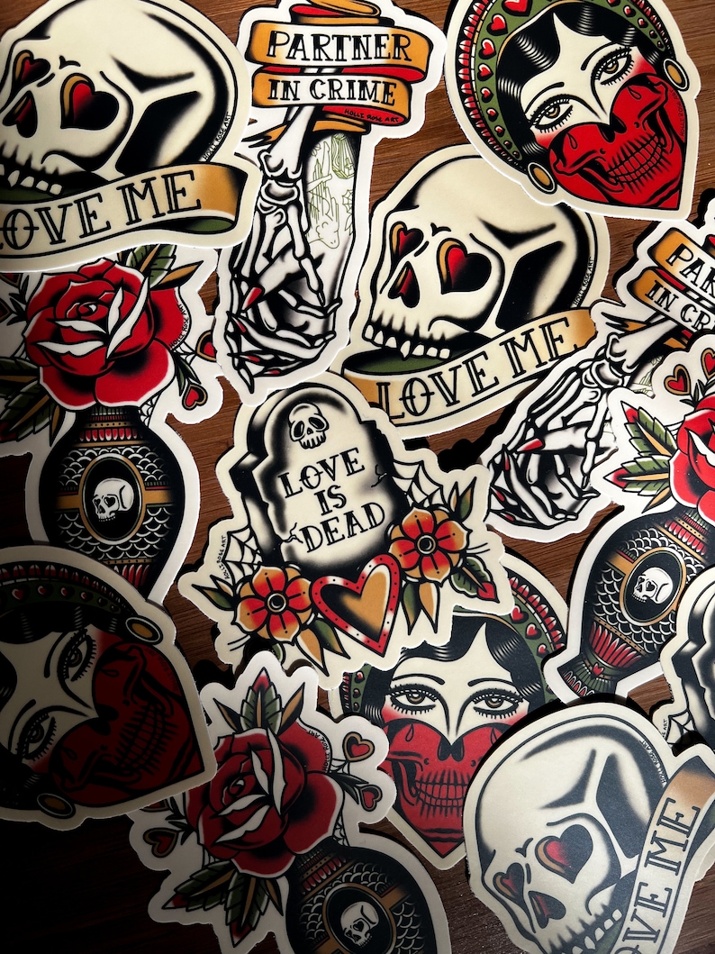May include: A collection of colorful, vintage-style tattoo flash designs. The designs include skulls, roses, hearts, and a skeleton hand. The text on the designs includes "Partner in Crime", "Love Me", "Love is Dead", and "Partner in Crime".