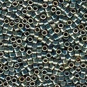 May include: A close-up view of a large quantity of small, dark blue and silver seed beads. The beads are opaque and have a slightly iridescent finish.