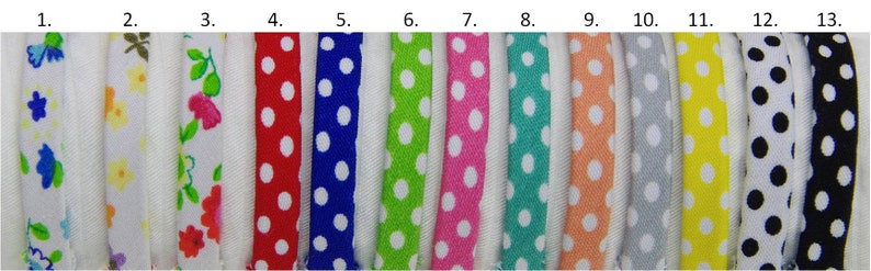 May include: Thirteen samples of white cotton ribbon with different colored polka dots. The colors are red, blue, green, pink, turquoise, orange, gray, yellow, black, and white.