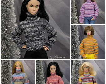Può includere: Sei bambole diverse che indossano maglioni a collo alto a righe colorate. I maglioni sono a maglia e hanno una varietà di colori e motivi.