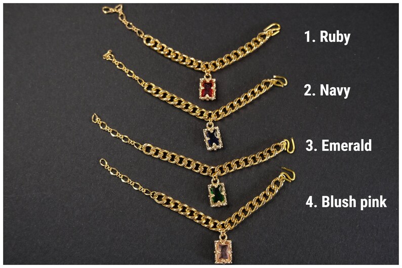 May include: Gold-toned chain jewelry with rectangular gemstone pendants in ruby, navy, emerald, and blush pink. The image shows four pieces of jewelry with different colored gemstones, each labeled with a number and color name.