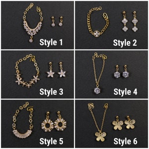 Pu&ograve; includere: Sei diversi stili di set di gioielli in oro con accenti di cristallo trasparente. Ogni set include una collana o un braccialetto e un paio di orecchini. Gli stili includono un design floreale, un design a farfalla e un design rotondo.