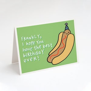 May include: A green card with a cartoon hot dog wearing a party hat. The text on the card reads "FRANKLY, I hope you have the best birthday ever!"