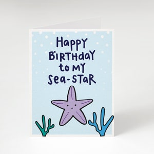May include: A folded greeting card with a light blue background and white polka dots. The card features the text "Happy Birthday to my Sea-Star" in dark blue. A purple starfish and green and blue coral are at the bottom.