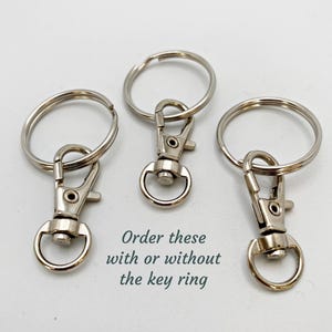 May include: Three silver keychains with a swivel clasp and a metal ring. Order these with or without the key ring.
