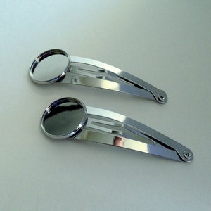 May include: Two silver hair clips with round, silver-toned, cabochon settings.