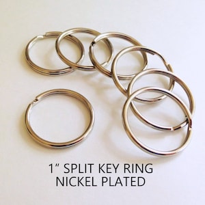 May include: A close-up of six 1-inch nickel-plated split key rings. The key rings are arranged in a circle on a white surface.