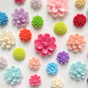 K&ouml;nnte beinhalten: Eine Auswahl an bunten, blumenf&ouml;rmigen Verzierungen in verschiedenen Farben, darunter Pink, Blau, Gr&uuml;n, Rot, Wei&szlig; und Gelb. Diese dekorativen Verzierungen eignen sich perfekt, um Ihren Bastelarbeiten, Schmuck und anderen Projekten einen Hauch von Verspieltheit zu verleihen.
