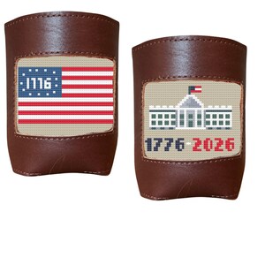 May include: Two brown leather drink sleeves. One features a stitched American flag with "1776" in the blue field. The other has a stitched image of the White House with "1776-2026" below.