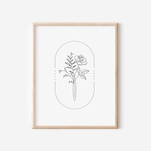 May include: A black and white line drawing of a rose with leaves inside an oval frame. The words "rose" and "june" are written vertically on either side of the frame.