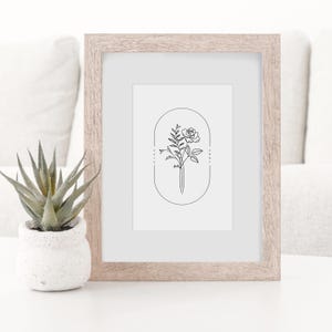 May include: A black and white line drawing of a rose and foliage in an oval frame. The drawing is in a light wood frame.