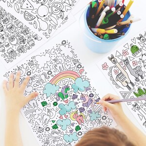 May include: A child colors a black and white coloring page with a rainbow, clouds, hearts, and unicorns. The child is using a gray colored pencil to color the page.