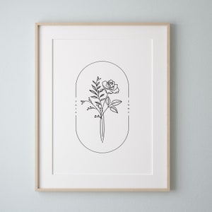 May include: A black and white line drawing of a rose with the words "rose" and "june" written vertically on either side of the flower.