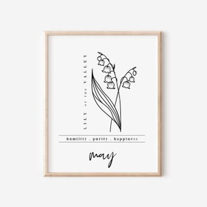 Peut inclure: Une affiche encadrée avec un dessin au trait noir de fleurs de muguet. Le texte "LILY OF THE VALLEY" est au-dessus des fleurs, avec "humilité . pureté . bonheur" et le mois "mai" en dessous. Le cadre est marron clair.